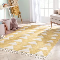 a yellow and white rug in a living room next to a chair with a teddy bear on it