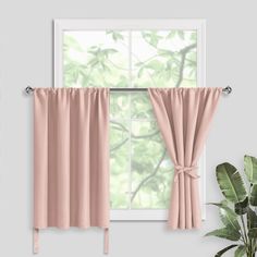 a window with pink curtains and a potted plant