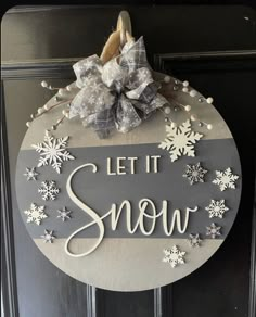 a sign that says let it snow hanging on a door with some decorations around it