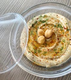 hummus in a glass bowl on top of a wooden table