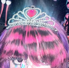 a close up of a person with pink hair and a tiara on their head