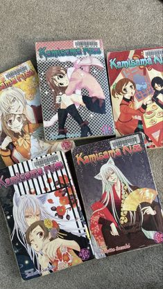 four anime books sitting on the floor next to each other