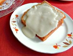 there is a piece of bread with icing on it sitting on a white plate