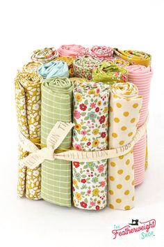 several rolls of fabric with flowers and polka dots on them, each rolled up in different colors