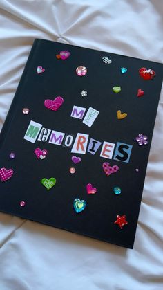 a black book with the word memories written in cut out letters and hearts on it