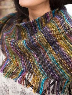 a woman wearing a multicolored knitted shawl