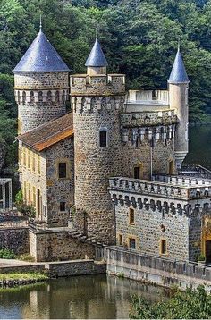 an old castle sits on the edge of a lake