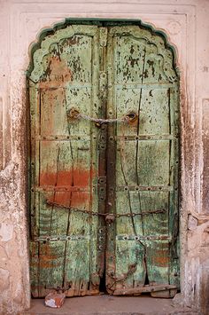 an old wooden door that has been painted green