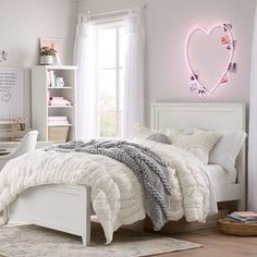 a bedroom with white furniture and a heart - shaped neon sign above the headboard