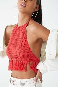 a woman wearing a red top with fringes on her neck and shoulders, standing in front of a white background