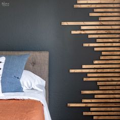 a bed with wooden slats on the headboard and pillows in front of it