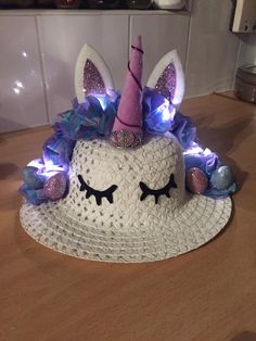 a white hat with purple and blue lights on it sitting on a wooden table next to a wall