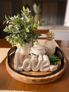 a tray that has some plants in it on top of a table with the word love spelled out