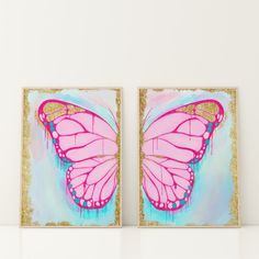 two pink and gold butterfly paintings on white wall