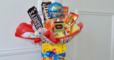 a birthday gift basket with candy, candies and balloons in it on the front door