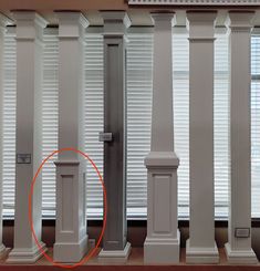 there is an orange circle in the middle of two columns with white trim on them