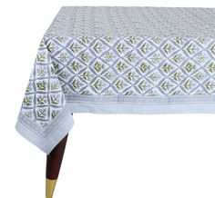 a blue and white table cloth with gold trimmings on the edges, featuring an abstract design