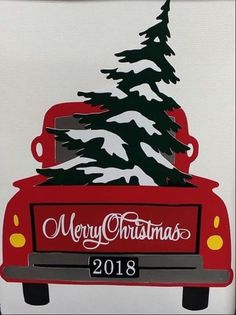 a red truck with a christmas tree on the back is parked in front of a white wall