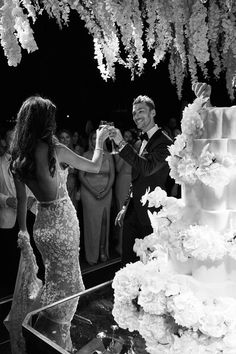 a bride and groom are cutting their wedding cake at the reception in black and white