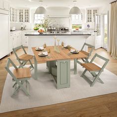 a kitchen with a table, chairs and an island in the middle of it is shown