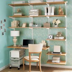 a desk with a laptop computer on top of it next to a shelf filled with books