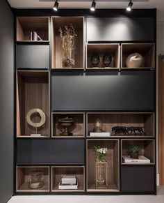 the shelves are filled with vases, books and other decorative items in black and brown