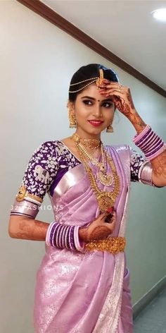 a woman in a pink sari holding her hands up to her face and looking at the camera