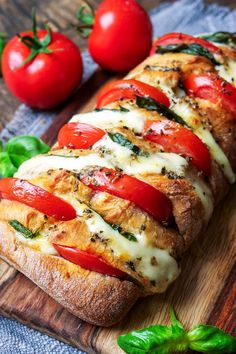 the bread has tomatoes and cheese on it, along with some basil sprigs