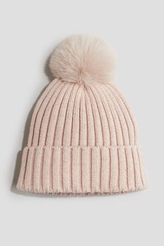 a light pink hat with a pom - pom on the front and side