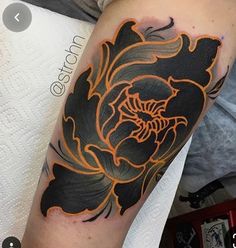 a black and orange flower tattoo on the arm