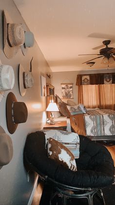 a bed room with a chair a ceiling fan and pictures on the wall