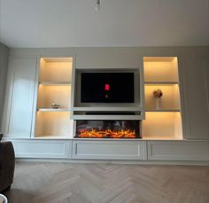 an entertainment center with built - in shelves and a fire place