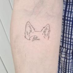 a small tattoo on the arm of a man with a dog's head and name