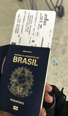 a person holding up a passport in front of an airport baggage claim machine with the word brasil on it