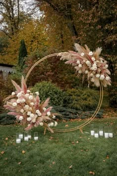 an outdoor wedding ceremony setup with flowers and candles in the center, surrounded by greenery