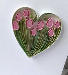 a paper heart with pink tulips in the center on a white card board