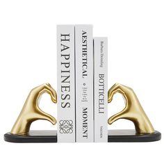 two bookends made out of gold and white books on top of each other