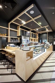 the interior of a restaurant with black and white striped flooring, wooden shelves and counter tops