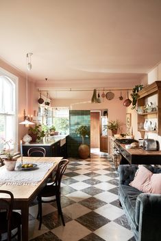 a kitchen with checkered flooring and lots of furniture in the middle of it