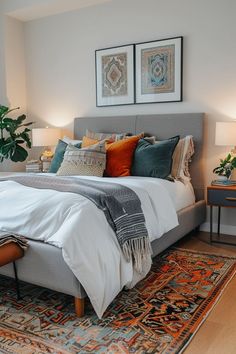 a bedroom with a bed, rug and two framed pictures