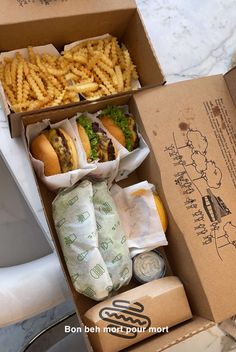 an open box with french fries, hamburgers and ketchup on the side