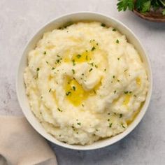 mashed potatoes in a white bowl with parsley on top