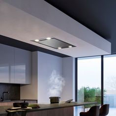 a modern kitchen with white cabinets and black counter tops, along with large windows looking out onto the outdoors