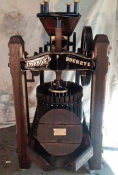 an old fashioned coffee grinder sitting on top of a wooden table next to a wall