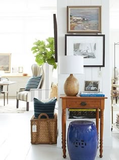 a living room with pictures on the wall and a blue stool in front of it