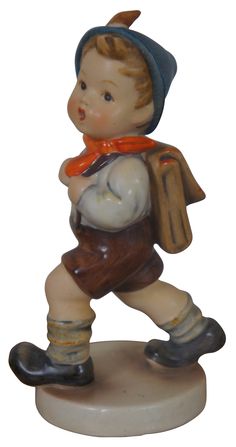 a figurine of a boy with a book in his hand