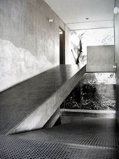 a black and white photo of a long metal stair case next to a planter