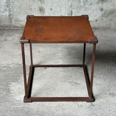 a small wooden table sitting on top of a cement floor