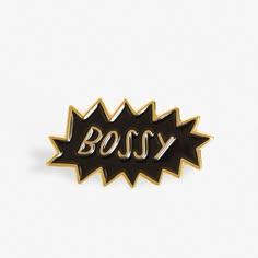 a black and gold pin with the word boss in it's center, on a white background