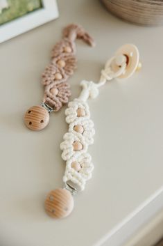 two wooden buttons are attached to a string on a table next to a framed photograph